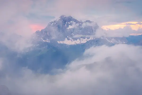 Mountain peak emerging through clouds at sunrise in the Italian Dolomites